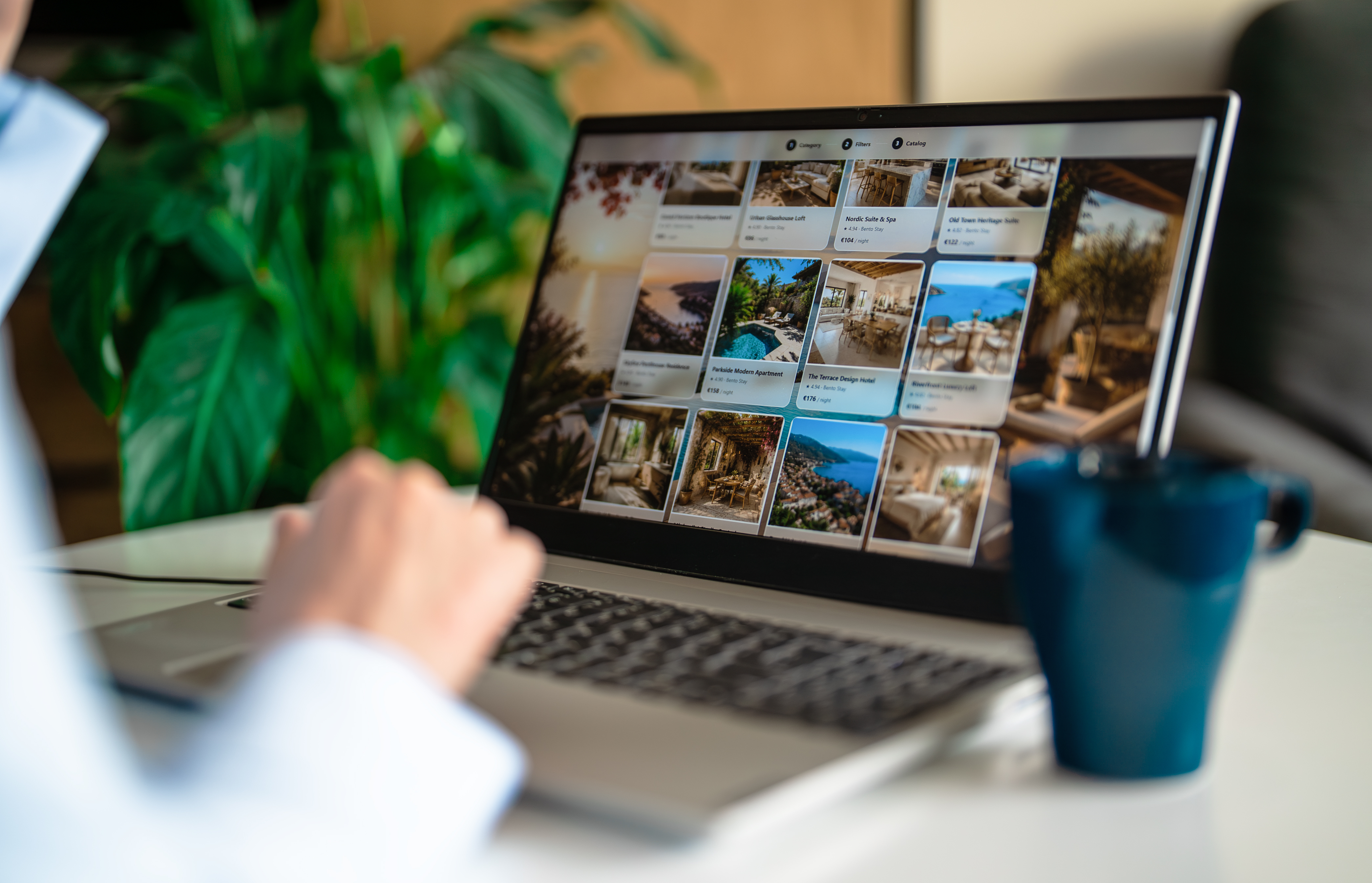 Woman browsing apartment catalog on laptop booking site.